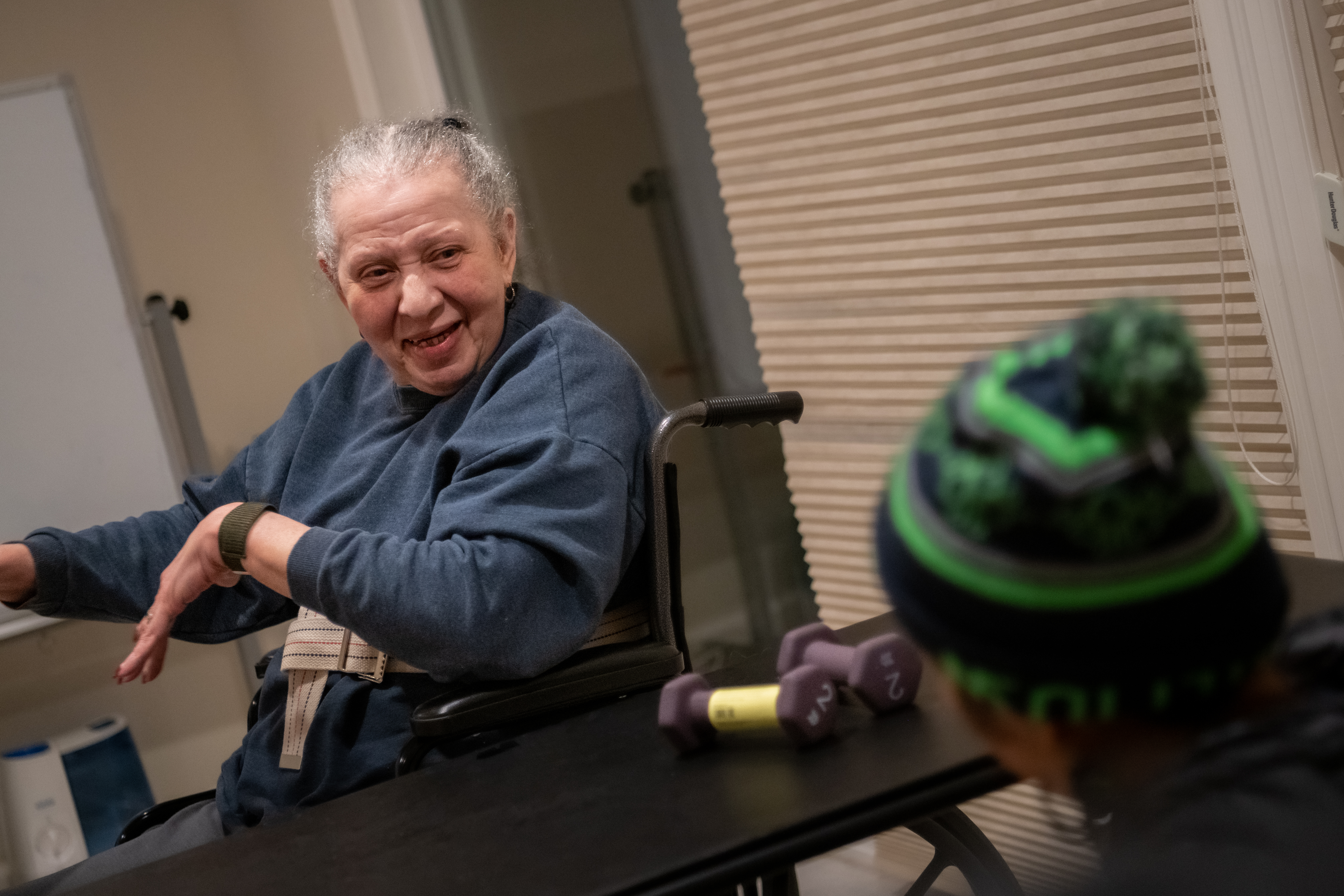 Older woman sitting in a wheelchair smiling