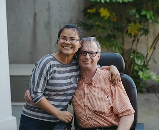 young woman and older man family members hugging and smiling 