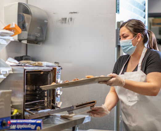 woman putting food in an oven